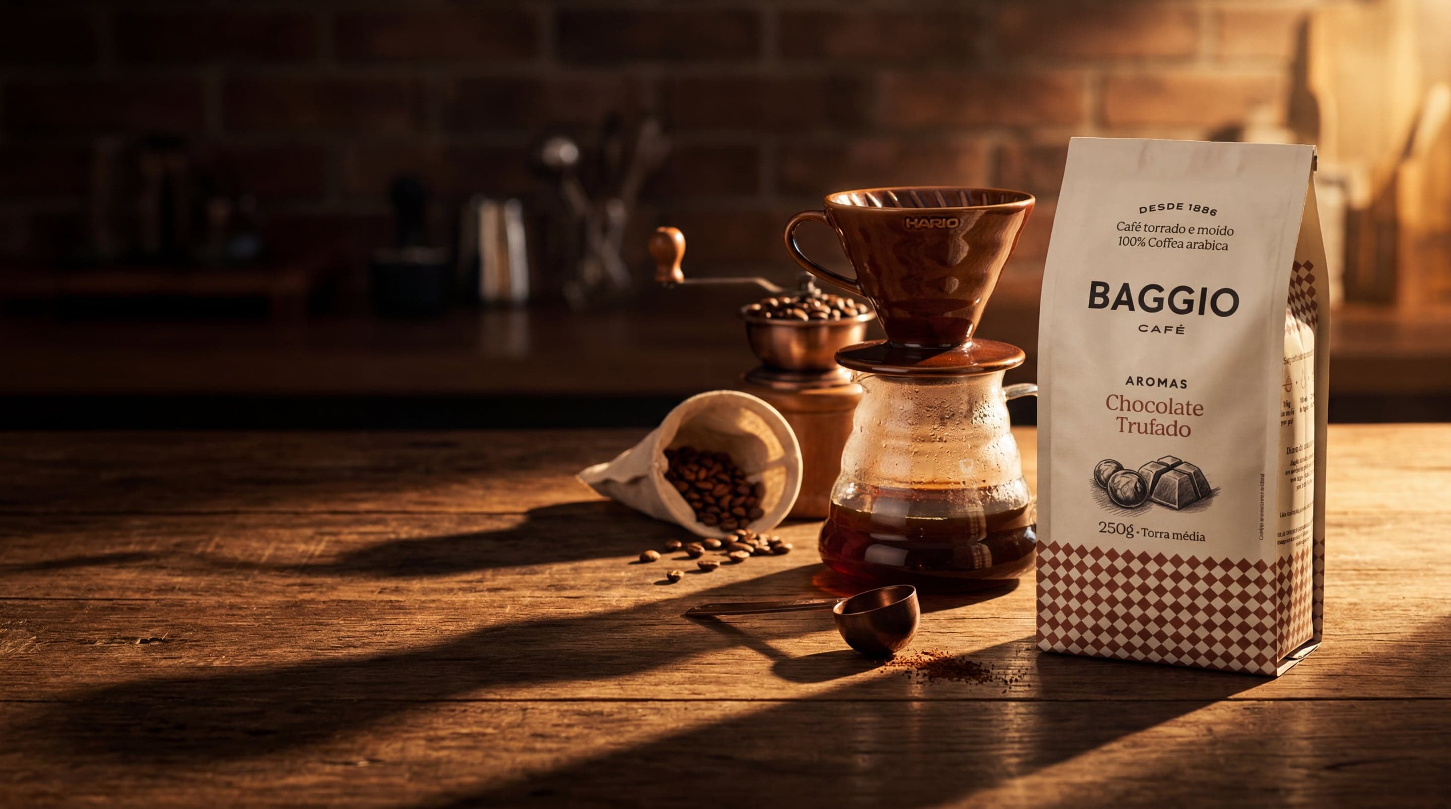 Baggio Café Aromas Chocolate Trufado bag with pour-over dripper, beans scattered on dark walnut, golden side light.